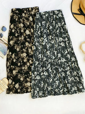 Botanical pleated midi skirts in black and taupe with a crinkled texture.