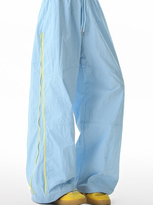 Men's pastel blue loose-fit casual sweatpants with yellow side stripe detail and drawstring.