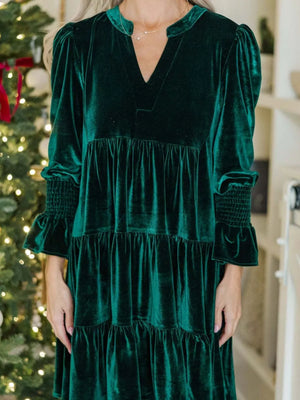 Dark green velvet tiered mini dress with V-neck and smocked cuffs.
