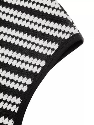 Black and white houndstooth knit maxi dress detail with black trim.