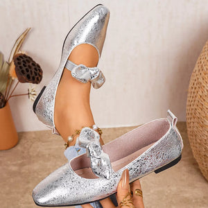 Chic silver slip-on flats with square toe and bow detail on ankle strap.