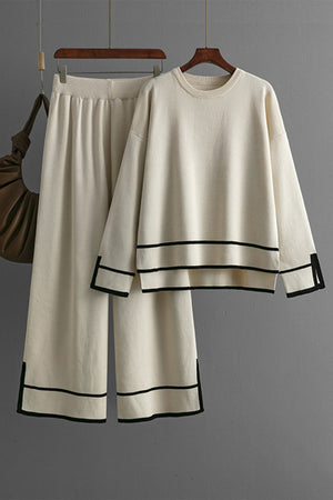 Cream acrylic loungewear set with round neck top and wide leg pants, featuring black trim details.