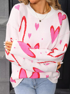 White acrylic crew neck sweater with allover pink and red hearts pattern.