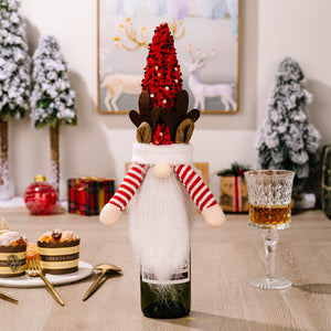 Festive gnome bottle topper with red sequin hat, antlers, white beard, and striped arms.