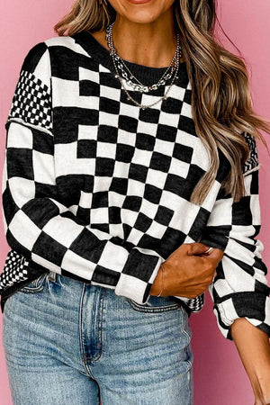 Black and white geometric knit checkerboard pullover sweater with crew neck and long sleeves.