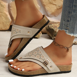 Beige hollow-out toe-post sandals with cork-style sole and adjustable ankle strap.