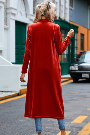 Deep Red velvet duster coat with long sleeves and open front, styled with jeans.