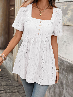 White eyelet babydoll top with square neck, puff sleeves, and decorative buttons.