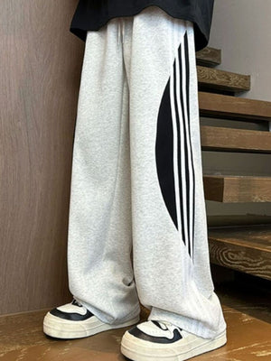Men's light gray wide leg casual trousers with black side stripe detail and drawstring.