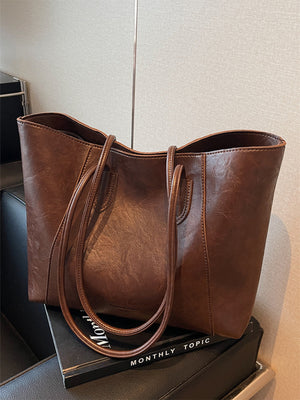 Brown crinkled PU leather tote bag with double straps and a spacious interior.