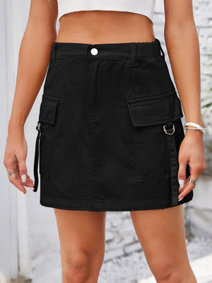 Black denim mini skirt with utility pockets, D-ring details, and zipper accents.