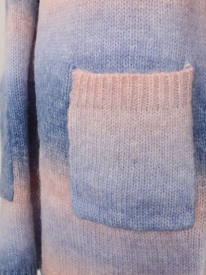 Rainbow gradient knit cardigan with a pink ribbed pocket detail.
