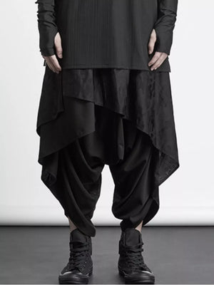 Black avant-garde harem sweatpants with asymmetrical layered detail and a dropped crotch.