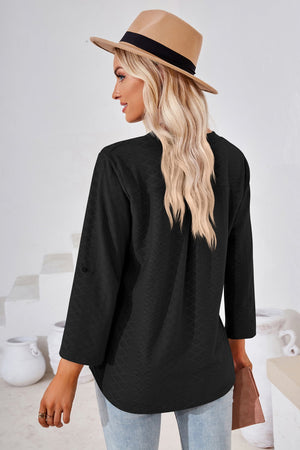 Black textured henley blouse with rolled sleeves and a curved hem.