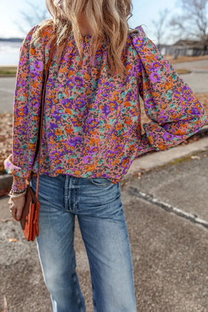 Purple floral print blouse with gathered puff sleeves and a mock neckline.