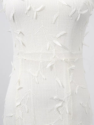White midi dress with floral applique detail and textured knit fabric.