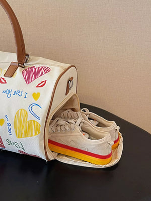 Vibrant canvas duffel bag with colorful heart print and brown trim, showing shoes inside.