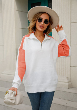 Colorblock zip-neck knit pullover in white with orange sleeves and side panels.