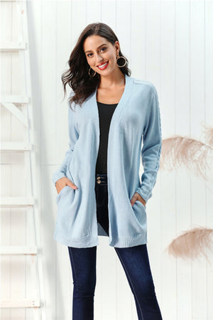 Light blue acrylic cable knit open front cardigan with pockets and braided sleeve detail.
