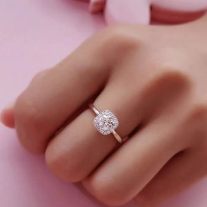 Elegant moissanite and sterling silver ring with cushion-cut center stone and halo.