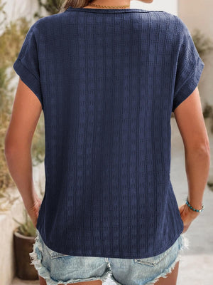 Navy woven texture cap-sleeve top with a relaxed fit, styled with denim shorts.
