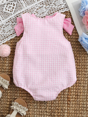 Baby one-piece in blush pink gingham with polka dot bows on sleeves