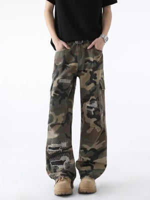 Men's distressed camouflage wide leg cargo pants with ripped details and belt.
