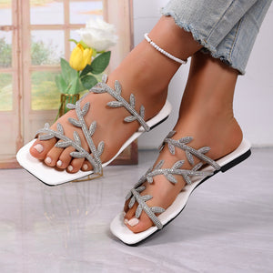 White open toe sandals with rhinestone leaf embellishments and a square toe.