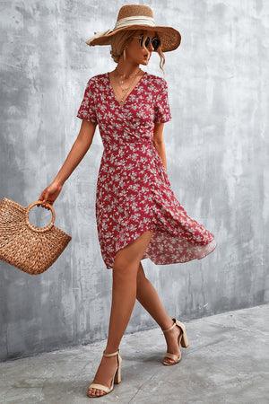 Crimson floral wrap midi dress with short sleeves and v-neck, styled with a straw hat and sandals.