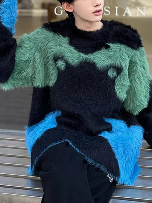 Oversized fuzzy color block sweater in black, green, and blue with asymmetrical design.