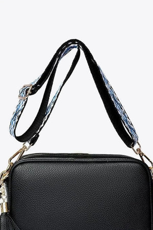 Black pebbled leather crossbody bag with patterned strap and tassel detail