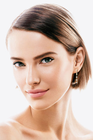 Gold 18K gold-plated dangling gemstone sterling hoop earrings with three small clear gems.
