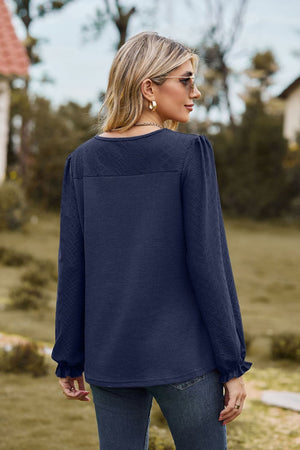 Dark Navy waffle knit blouse with perforated detail and ruffled cuffs.