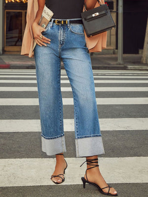 Light wash denim jeans with wide legs and large cuffed hems.