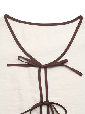 Beige tie-front two-piece ensemble with brown trim and bow details.