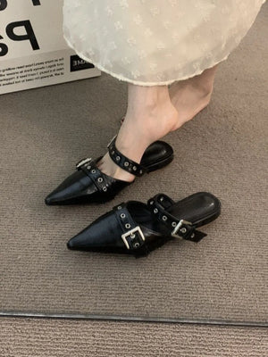 Black pointed mules with buckle and stud details.