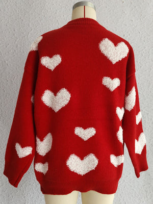 Red knit sweater with textured white heart appliqués, long sleeves, and crew neck.