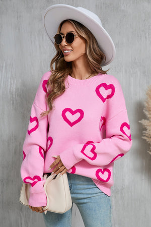 Pink acrylic knit pullover sweater with a repeating hot pink heart intarsia pattern.