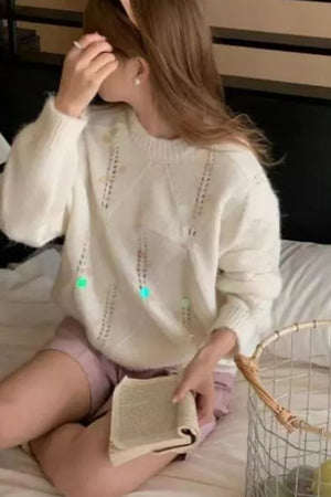Ivory diamond knit sweater with sequin embellishments and open knit details.
