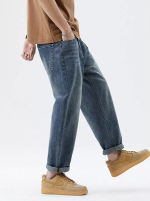 Men's blue washed stretch denim jeans with cuffed hems.