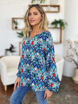 Prismatic ikat blouse in blue with voluminous sleeves and V-neck.