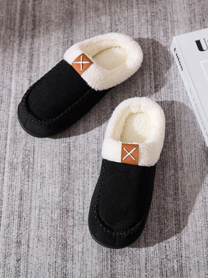 Black suede shearling-lined moccasin slides with a decorative stitched detail and tan accent.