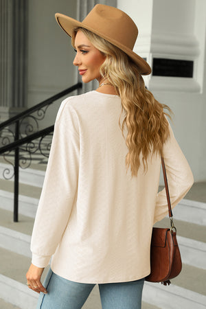 Cream textured henley v-neck top with long sleeves and a relaxed fit.