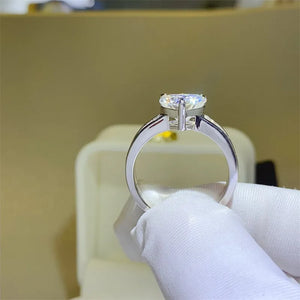 Silver band ring with a heart-cut moissanite and baguette accents.