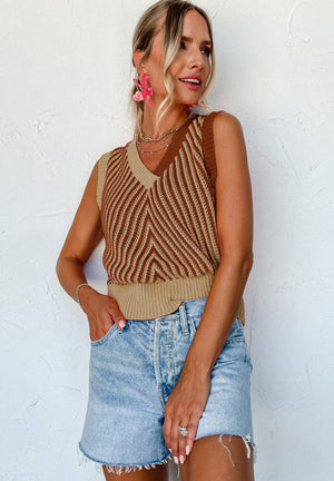 Chevron knit vest in brown and tan with V-neck and ribbed hem, styled with denim shorts.