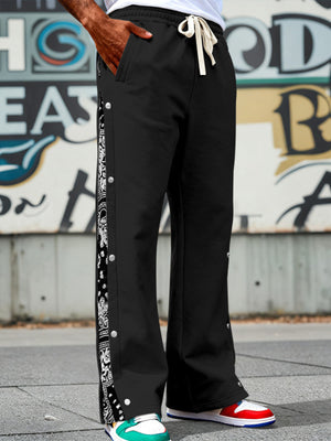 Black sweatpants with side snaps and bandana print stripe detail.