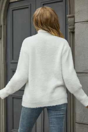 White fluffy mock neck sweater with long sleeves and ribbed cuffs.