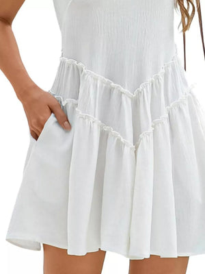 White frill tiered mini dress with pockets and ruffled details.