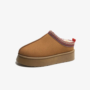 Camel shearling trim platform mules with patterned trim and red pull tab.