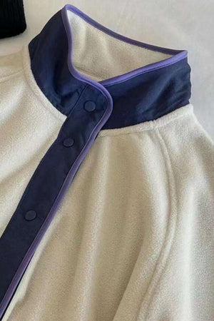 Fleece bomber jacket in light gray with navy and purple contrast trim and snap closure.